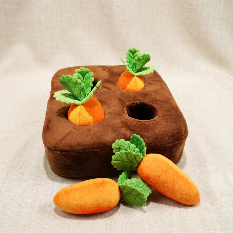 CozyPaws carrot snuffle mat 4-carrot version with brown plush base showing two carrots inserted in holes and two plush carrots with green felt leaves lying beside